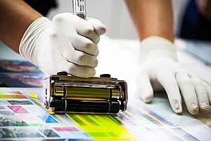 an individual adding commercial print coating to marketing material