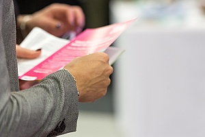 individuals reading business flyers they received for an event