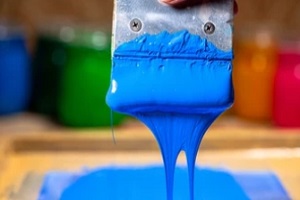 man holding screen printing block with blue ink