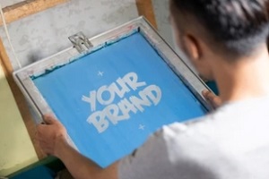 man holding screen printing board