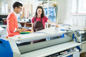 beautiful lady in apron showing printed banner to manager