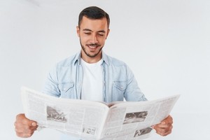 A man reading newspaper with joy