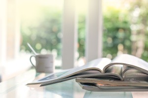 Magazines and a mug placed near the window