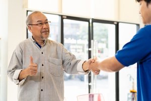A man shaking hands with a local shop owner