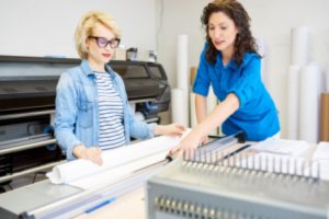 Two women are preparing commercial brochures printing setup