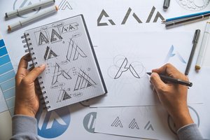 A person creating custom business graphics using paper and pencil