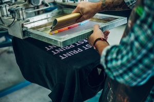 A man screen printing a T-shirt