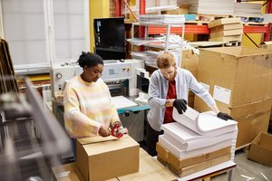 Two workers working inside a commercial printing factory